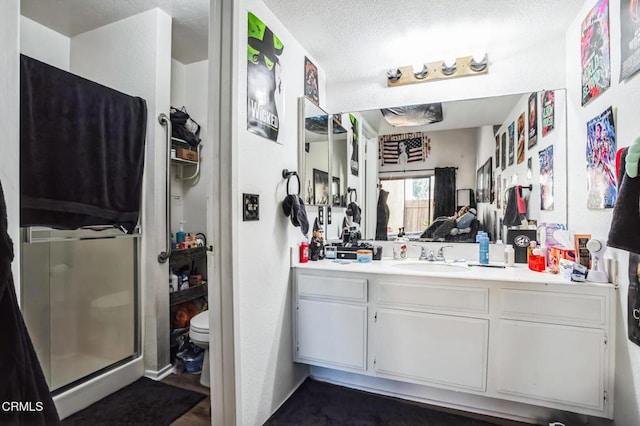 full bath featuring toilet, a stall shower, and vanity