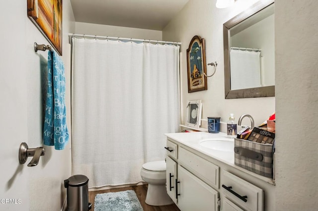 bathroom featuring a shower with curtain, toilet, wood finished floors, and vanity