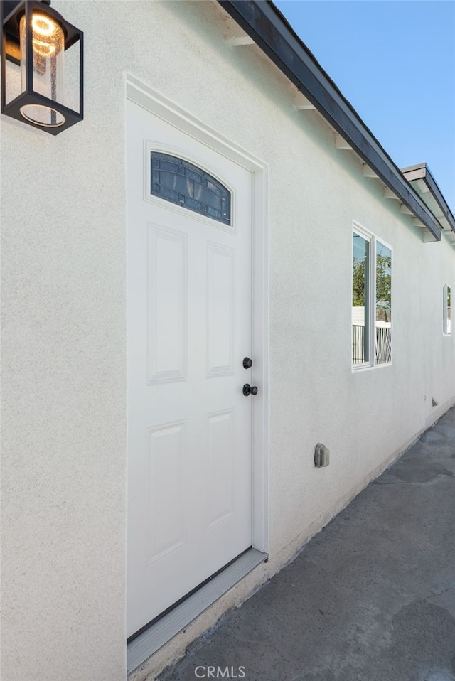 doorway to property featuring stucco siding