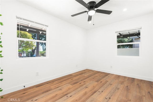 unfurnished room featuring baseboards, a ceiling fan, and light wood-style floors