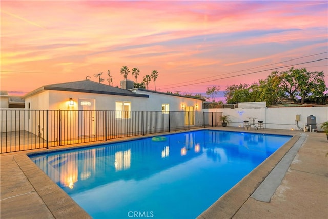 view of swimming pool featuring a patio area, fence, a fenced in pool, and central air condition unit