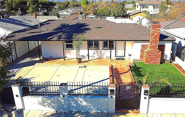 ranch-style home with a fenced front yard, stucco siding, a shingled roof, a residential view, and a front lawn