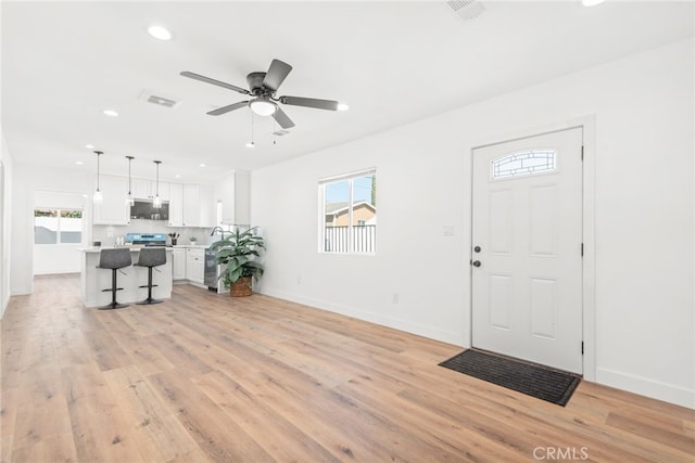 foyer featuring light wood-style flooring, visible vents, baseboards, and recessed lighting