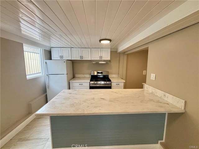 kitchen featuring stainless steel gas range oven, under cabinet range hood, a peninsula, wood ceiling, and freestanding refrigerator