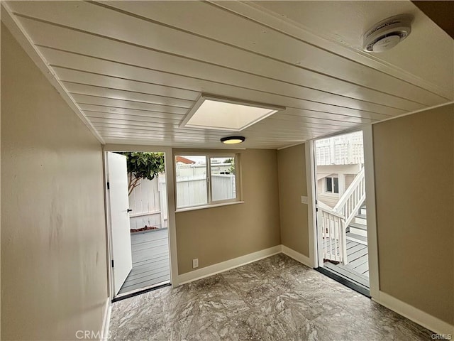 interior space with wooden ceiling and baseboards