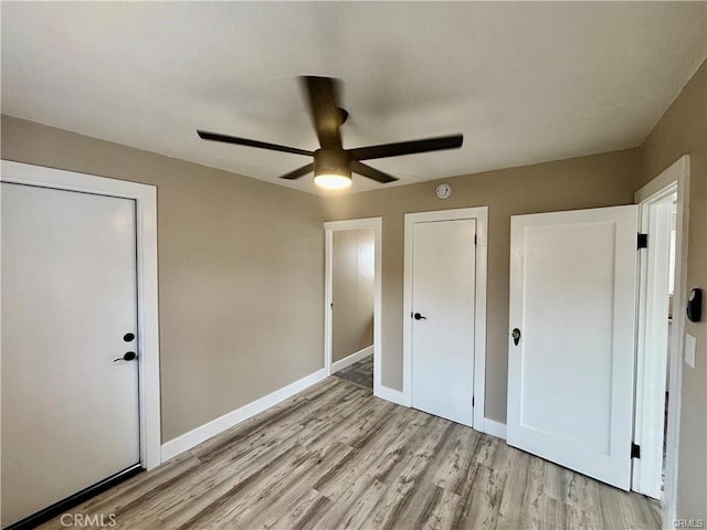 unfurnished bedroom featuring baseboards, ceiling fan, and light wood finished floors