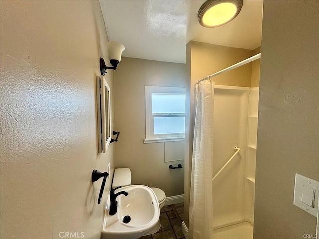 full bathroom featuring toilet, a shower stall, and baseboards