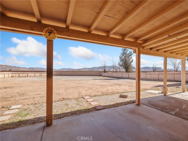 view of patio featuring a mountain view and fence