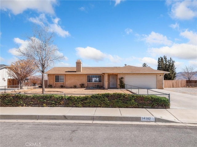 view of front of house featuring a garage, concrete driveway, a fenced front yard, and stucco siding