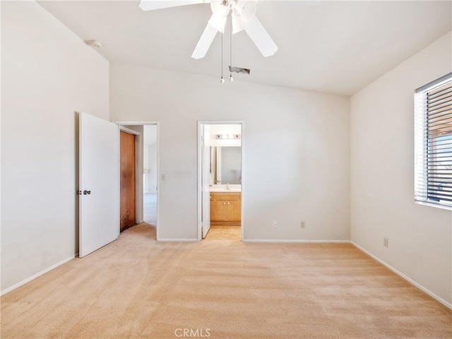 unfurnished bedroom with light colored carpet, visible vents, ensuite bathroom, ceiling fan, and baseboards