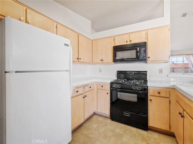 kitchen featuring black appliances, visible vents, and light brown cabinetry