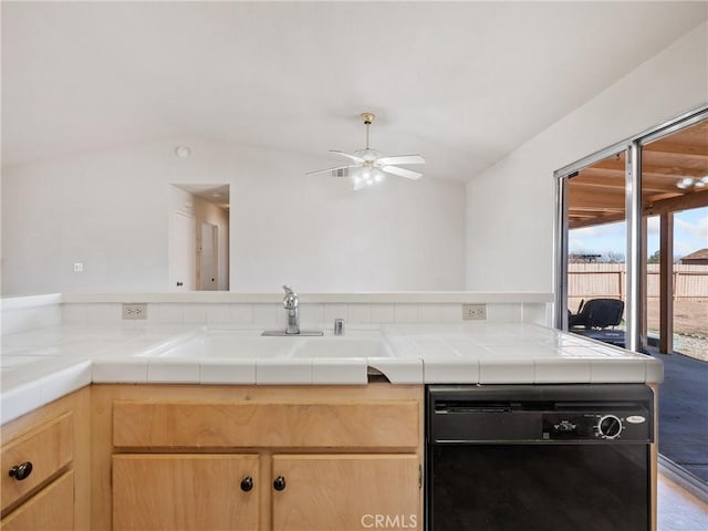 kitchen with black dishwasher, light brown cabinets, a sink, and tile countertops