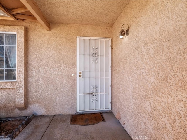 property entrance featuring stucco siding