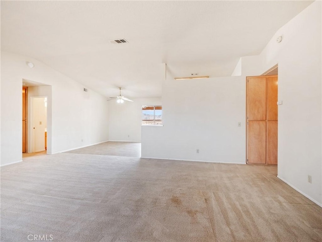 unfurnished room with visible vents, vaulted ceiling, a ceiling fan, and light colored carpet