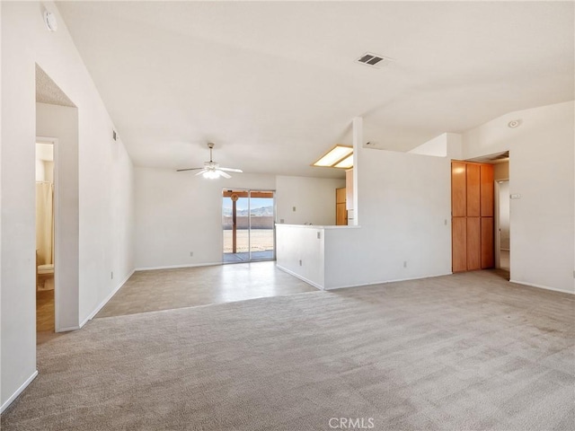 carpeted empty room with baseboards, visible vents, and a ceiling fan