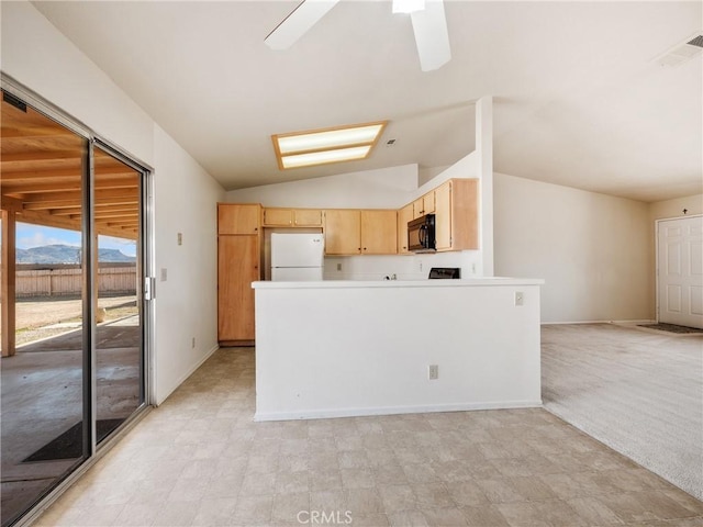 kitchen with visible vents, lofted ceiling, freestanding refrigerator, light brown cabinets, and black microwave