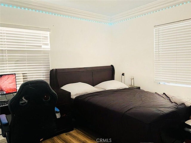 bedroom featuring wood finished floors and crown molding