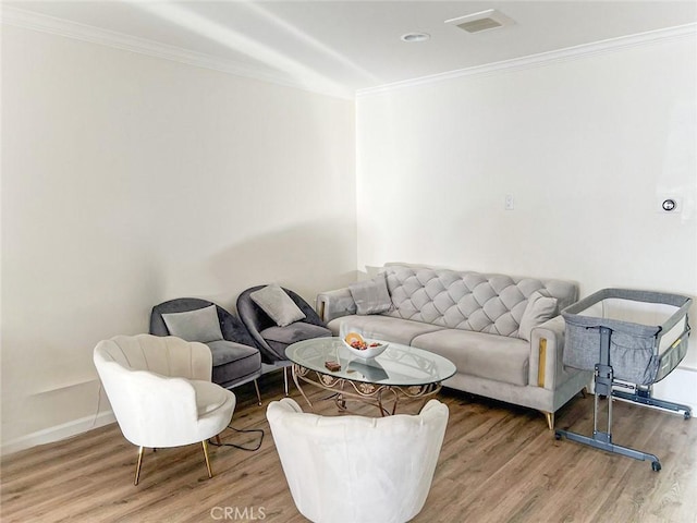 living area with crown molding, baseboards, and wood finished floors