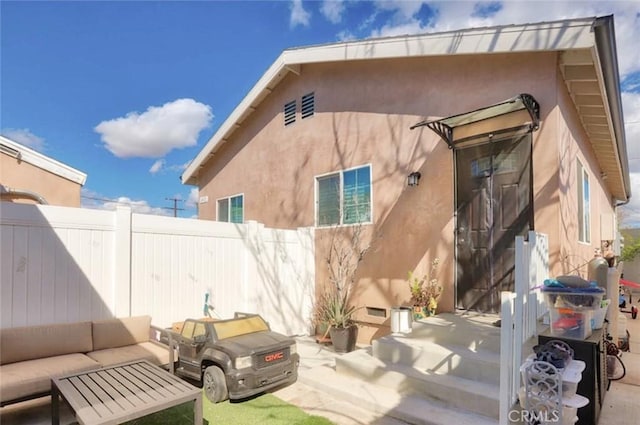 back of property featuring a patio, fence, and stucco siding