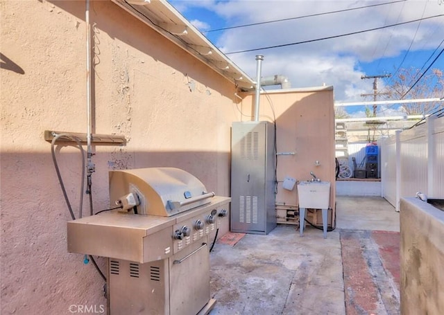 view of patio with exterior kitchen, fence, grilling area, and a sink