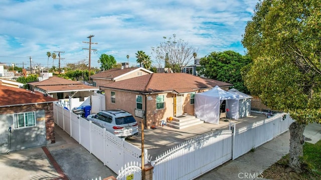 view of front facade featuring a fenced front yard, a gate, and stucco siding