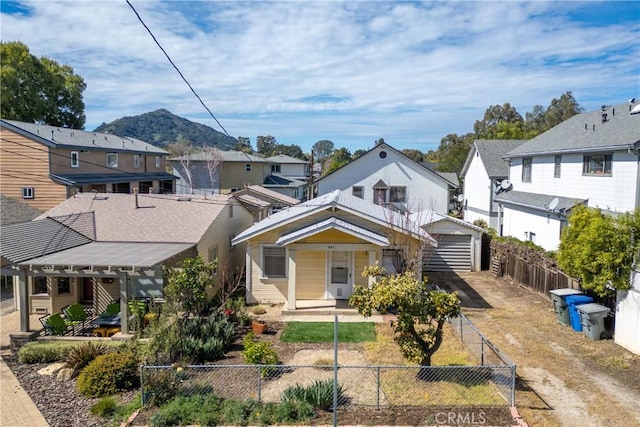 view of front of property with a fenced front yard, a residential view, and a pergola