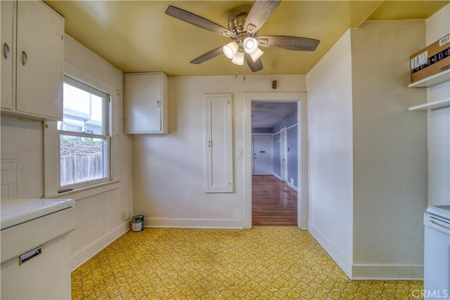 interior space featuring light countertops, baseboards, light floors, and white cabinetry