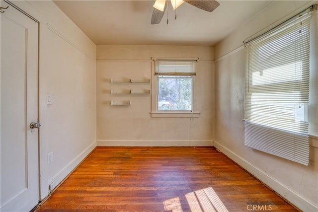 spare room featuring ceiling fan, wood finished floors, and baseboards