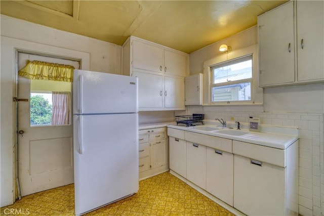 kitchen featuring freestanding refrigerator, light countertops, and light floors