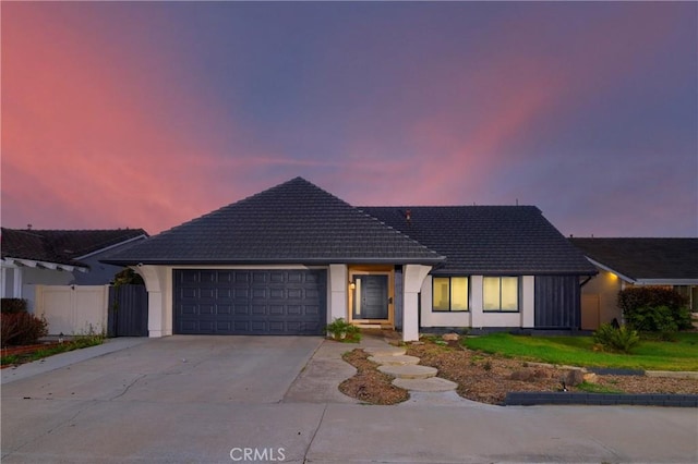 single story home featuring a garage, fence, concrete driveway, and a tiled roof