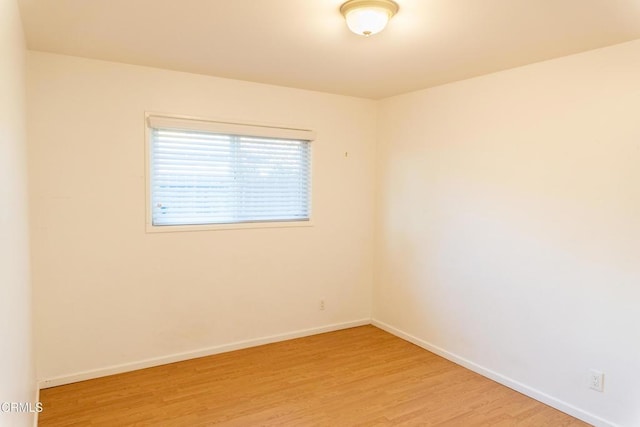 spare room with light wood-style flooring and baseboards