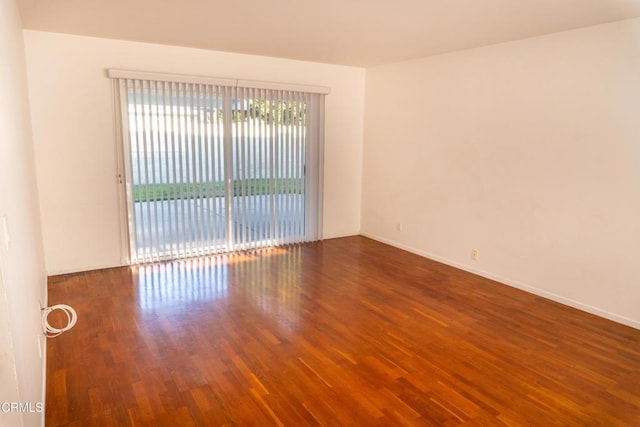 unfurnished room featuring baseboards and wood finished floors