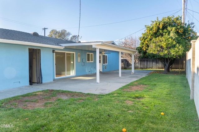 back of property featuring a patio area, a fenced backyard, a ceiling fan, and a yard