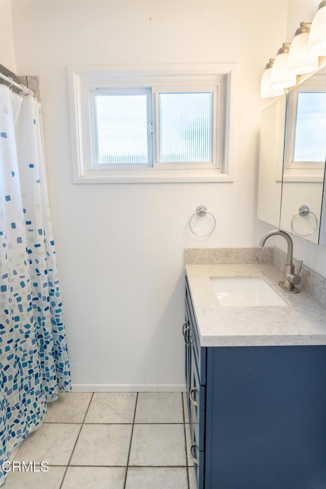 bathroom featuring a shower with shower curtain, tile patterned flooring, vanity, and baseboards