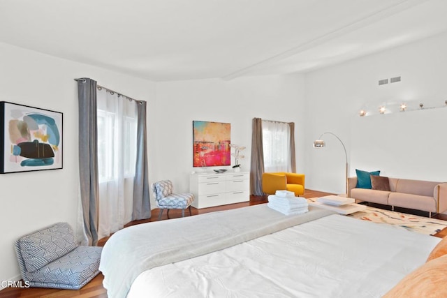 bedroom featuring lofted ceiling, visible vents, and wood finished floors