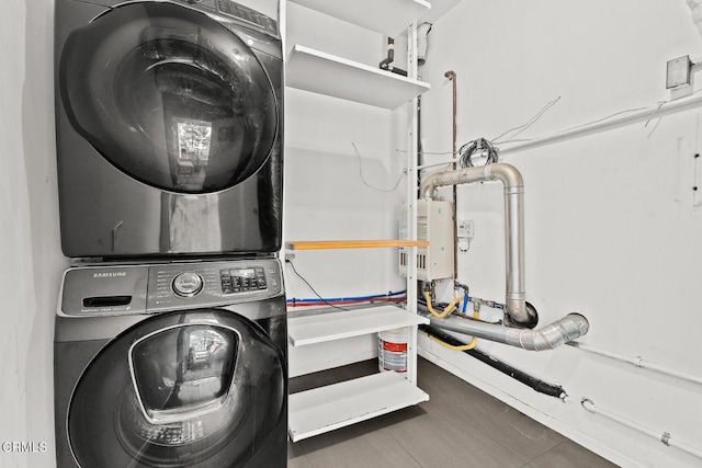 washroom featuring stacked washer and dryer and laundry area