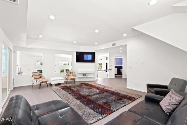 living area with recessed lighting, visible vents, lofted ceiling, and baseboards