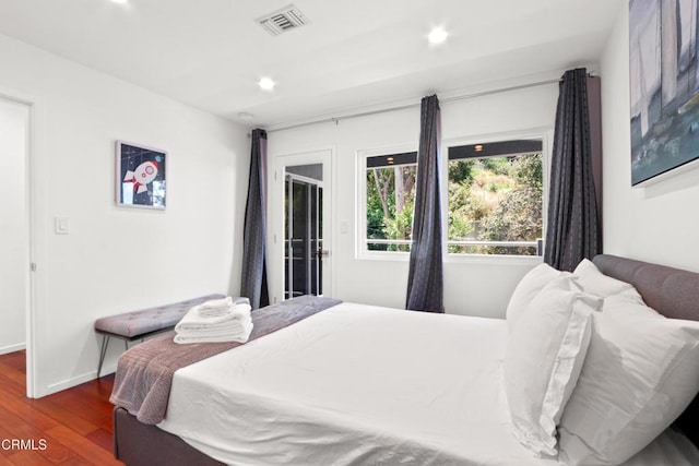 bedroom featuring baseboards, wood finished floors, visible vents, and recessed lighting