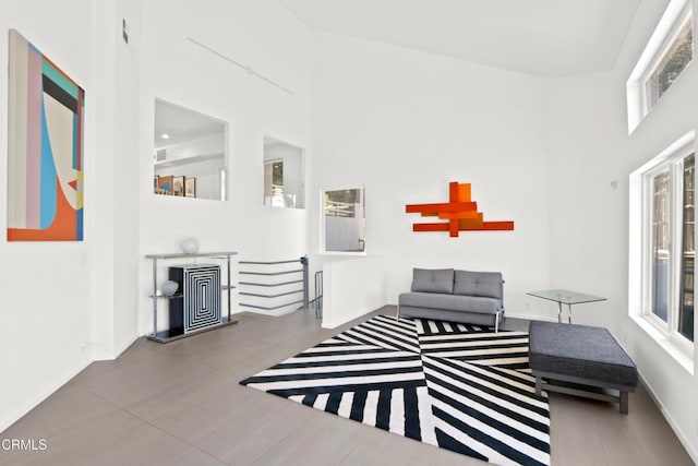 living area with a towering ceiling and baseboards