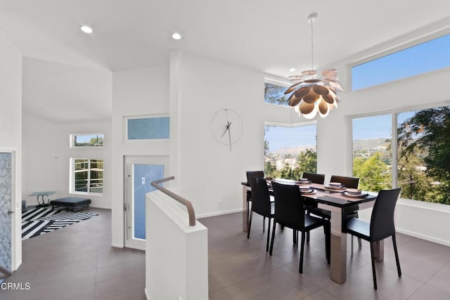 dining area with baseboards, a high ceiling, and recessed lighting