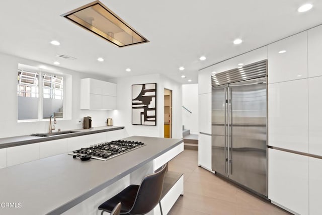 kitchen featuring stainless steel appliances, white cabinetry, a sink, and modern cabinets