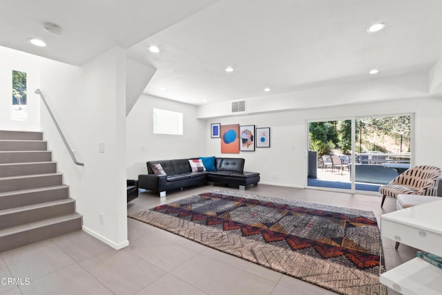 tiled living room with stairs, visible vents, a wealth of natural light, and recessed lighting