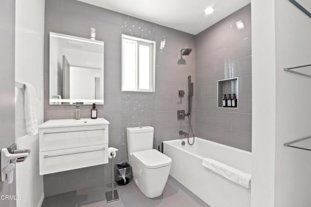 full bath featuring tile walls, shower / bathing tub combination, toilet, vanity, and tile patterned floors