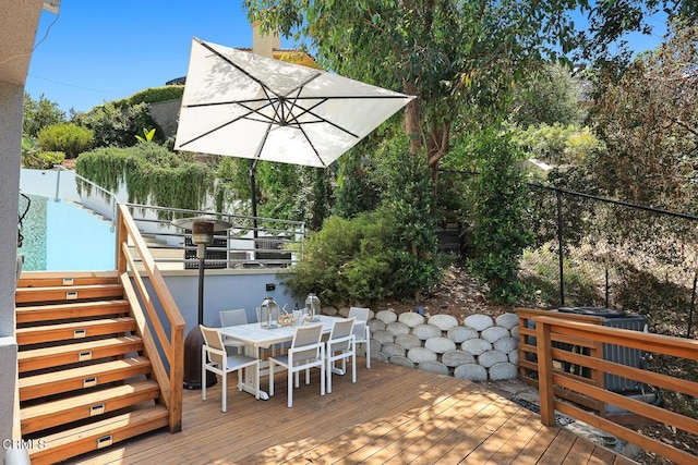 deck featuring stairs, outdoor dining area, and fence