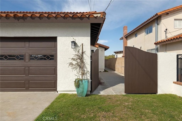 view of home's exterior with a garage, fence, and stucco siding