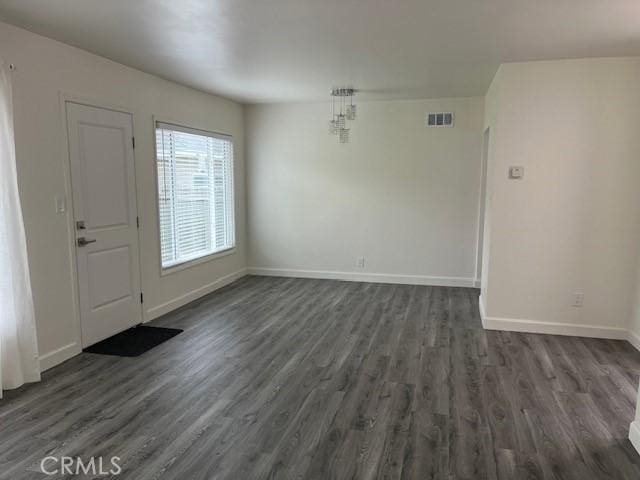 foyer featuring dark wood-style flooring, visible vents, and baseboards