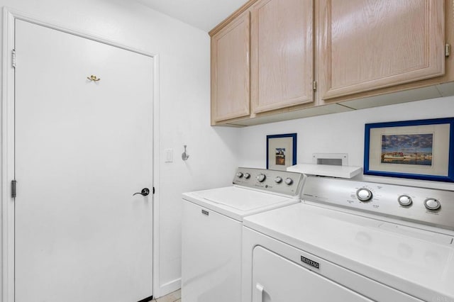 clothes washing area with washing machine and dryer and cabinet space