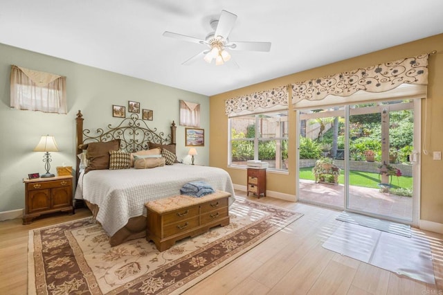 bedroom featuring access to outside, multiple windows, light wood-type flooring, and baseboards