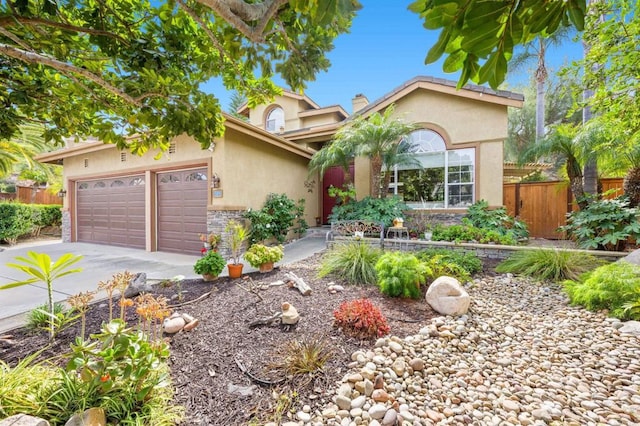 view of front of house with an attached garage, fence, concrete driveway, stucco siding, and a chimney