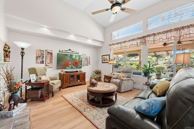 living area with a ceiling fan, baseboards, high vaulted ceiling, and light wood finished floors